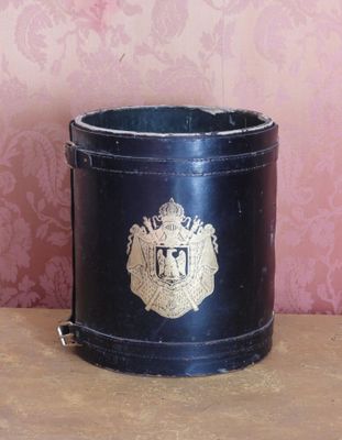 un petit seau noir orné d'un emblème doré