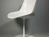 une chaise blanche posée sur un socle blanc