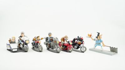 plusieurs figurines représentant des personnes à moto et des motos, posées sur une surface blanche