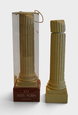 a small statue of a man standing next to a tall pillar