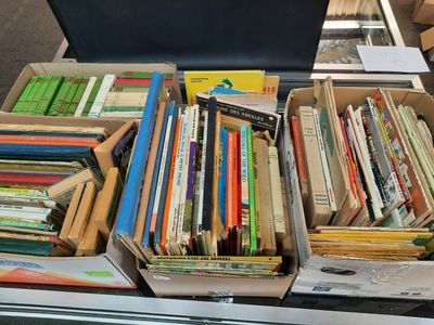 Des cartons remplis de livres sont empilés les uns sur les autres sur une table