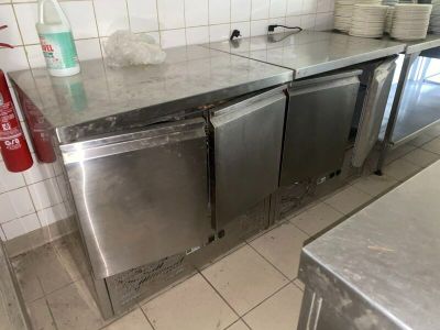 plan de travail en acier inoxydable dans une cuisine professionnelle, avec de la vaisselle posée dessus