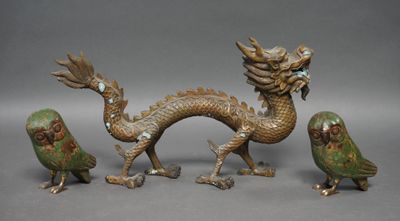trois figurines en bronze représentant des oiseaux et un dragon sur fond gris