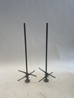 a pair of black metal candles on stands with a white background
