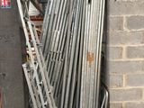 a pile of metal pipes leaning against a brick wall