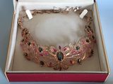 une boîte rose contenant un collier doré et noir