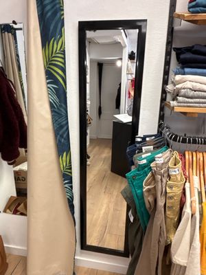 un grand miroir dans un coin d'un magasin de vêtements