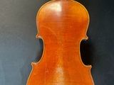 an antique violin with a wooden back and bow on a black background
