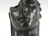 une image représentant une sculpture représentant une tête d'homme sur une surface blanche