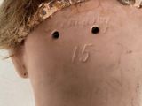 a close up of a doll ' s head with hair on it