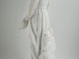 a statue of a woman holding a dog on a white surface
