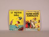 Deux livres sont posés l'un à côté de l'autre sur une surface blanche