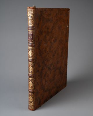 un vieux livre à la couverture brune posé sur une table