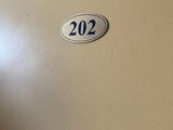 une photo d'une porte sur laquelle figure le numéro 202