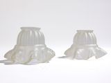 deux vases blancs posés sur une surface blanche, sur fond blanc