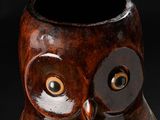 a brown owl shaped vase sitting on a black surface