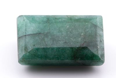 gros plan d'une pierre d'émeraude verte sur une surface blanche