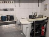a small kitchen with a sink and a toilet in it