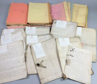 a pile of old books with papers on them sitting on top of a table