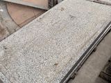 a pile of granite on the ground next to a building