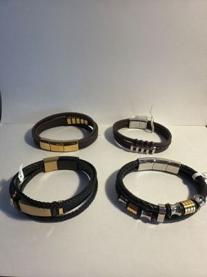 four different types of leather bracelets on a white surface