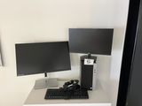 a computer desk with two monitors and a keyboard on it
