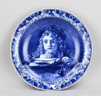 assiette bleue et blanche ornée d'une peinture représentant une femme tenant un livre