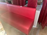 a red bench that is sitting in front of a red curtain