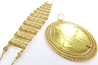 two pieces of jewelry that include a gold coin and a chain