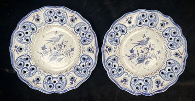 two blue and white plates with birds and flowers on them