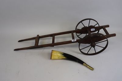an antique wooden wagon with a brush next to it on a white surface