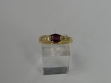 an image of a gold ring with a ruby stone on it