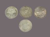 a group of five different coins sitting on top of a table