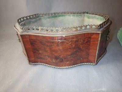 une vieille boîte en bois posée sur une table, à côté d'un tissu vert