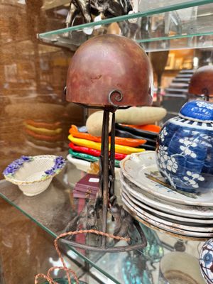 une étagère en verre sur laquelle sont posées des assiettes, des bols et une lampe