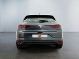the rear end of a grey car in a white room