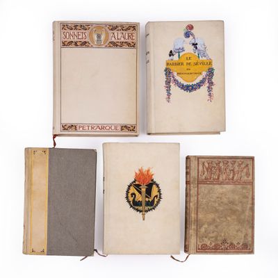 trois vieux livres sont alignés sur une surface blanche