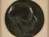 an image of a black medallion with a man ' s face on it