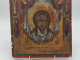 an old wooden icon of a man with a beard and a cross