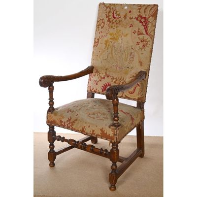 FAUTEUIL LOUIS XIII à haut dossier en noyer à décor sculpté.