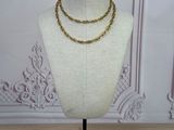 gold chain necklace on a mannequin on a wooden table