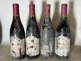 four bottles of wine are lined up on a table