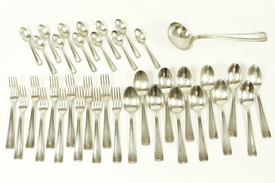 de nombreuses cuillères et fourchettes disposées sur la table