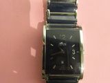 une image représentant une montre-bracelet posée sur un fond rose