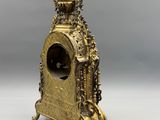 an image of a gold clock sitting on top of a table