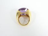 a close up of a gold ring with a purple stone
