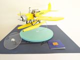 a model of a yellow airplane on a blue surface