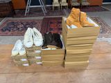 Plusieurs cartons de chaussures sont empilés les uns sur les autres sur une table en bois