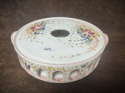un bol blanc orné de fleurs, posé sur une surface marron