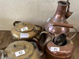 trois casseroles et une bouilloire posées sur un plancher en bois